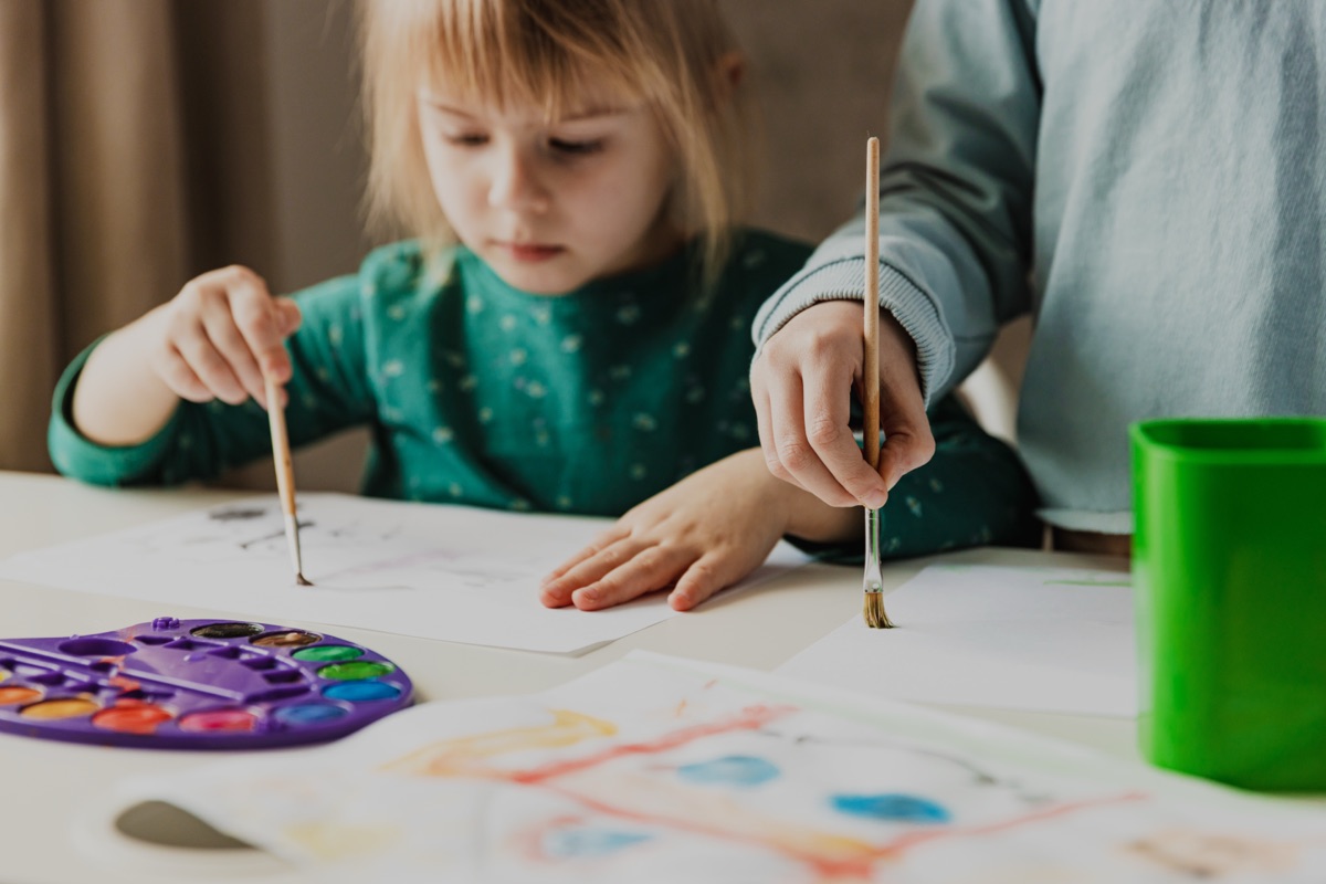 Preschool room at Young Explorers Club, Dublin 15: a child painting with an educator